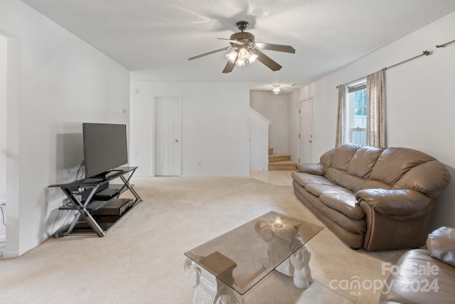 carpeted living room with a textured ceiling and ceiling fan