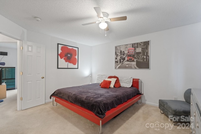 bedroom featuring light carpet, a textured ceiling, and ceiling fan