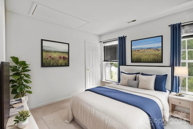 bedroom with multiple windows and light colored carpet