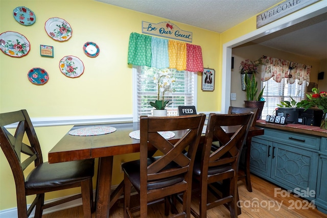 dining area with a textured ceiling and hardwood / wood-style flooring