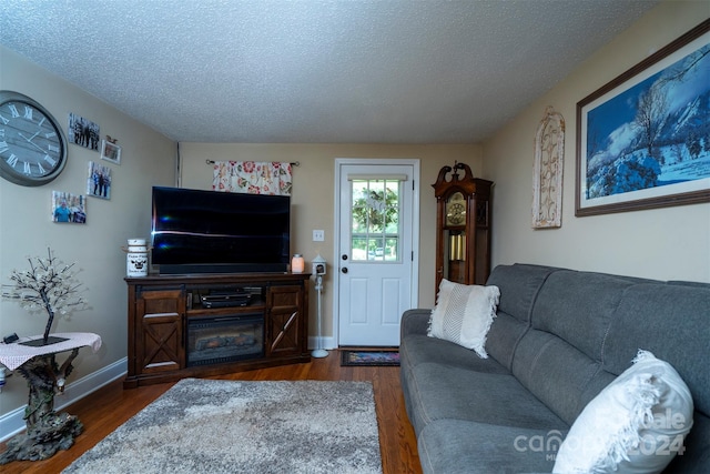 living room featuring dark wood-type flooring and a textured ceiling