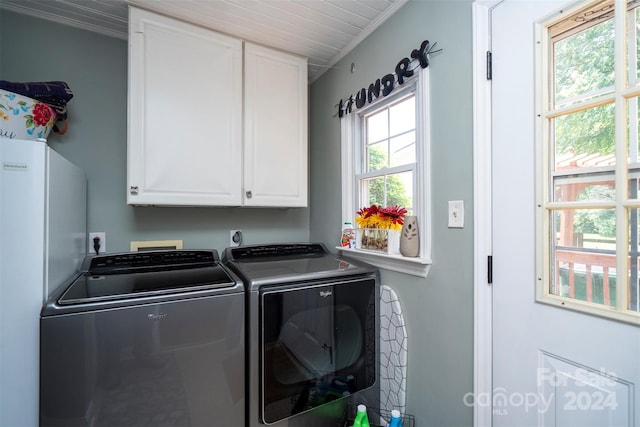 laundry area with ornamental molding, a healthy amount of sunlight, cabinets, and washing machine and clothes dryer