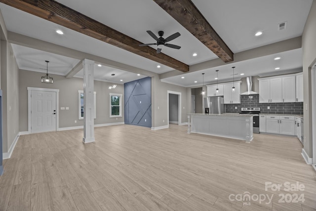 unfurnished living room with ceiling fan, beamed ceiling, light wood-type flooring, and decorative columns