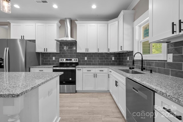 kitchen featuring light hardwood / wood-style floors, sink, white cabinets, wall chimney exhaust hood, and stainless steel appliances