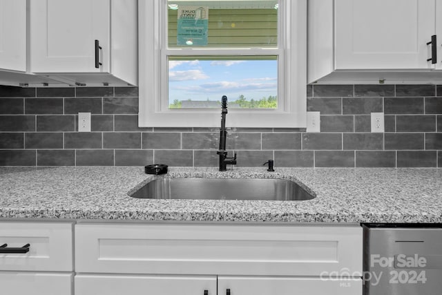 kitchen with decorative backsplash, white cabinetry, and sink