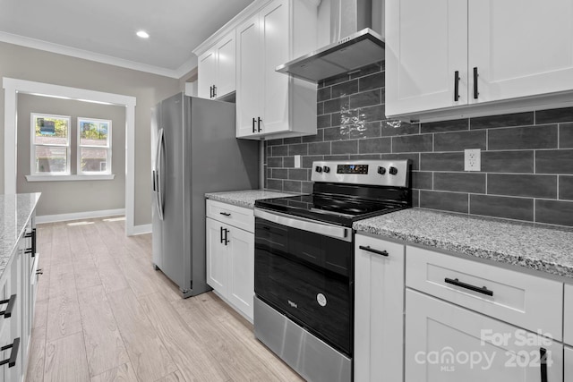 kitchen featuring light hardwood / wood-style floors, white cabinetry, wall chimney range hood, stainless steel appliances, and crown molding