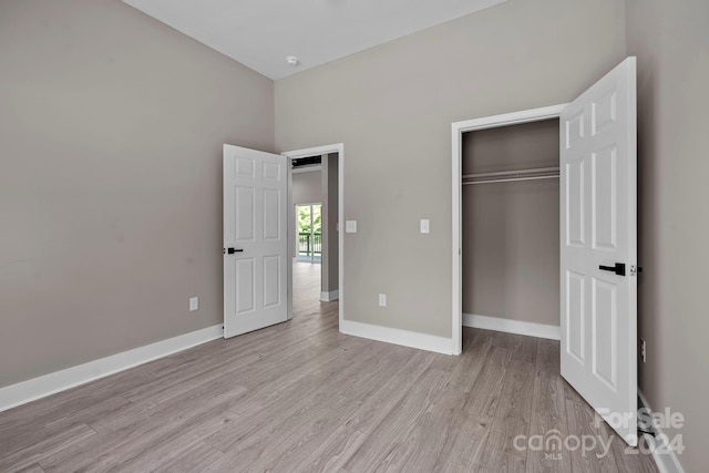 unfurnished bedroom featuring light hardwood / wood-style flooring and a closet