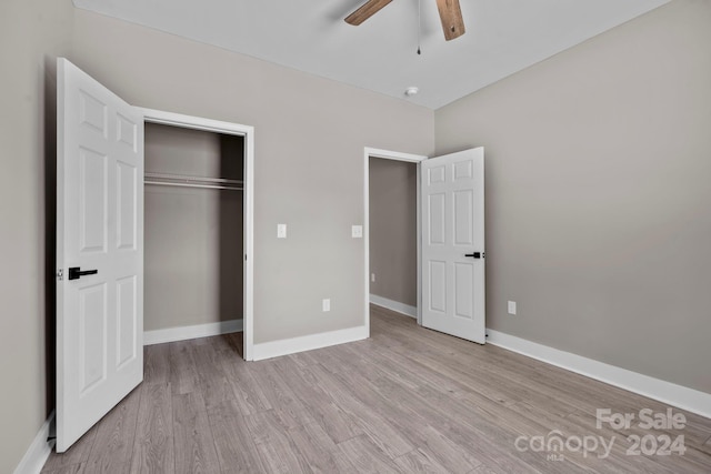 unfurnished bedroom with ceiling fan, light hardwood / wood-style flooring, and a closet