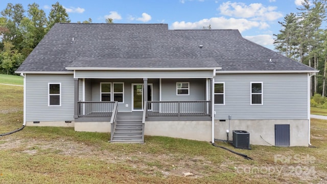 rear view of property featuring a lawn, central AC unit, and a porch