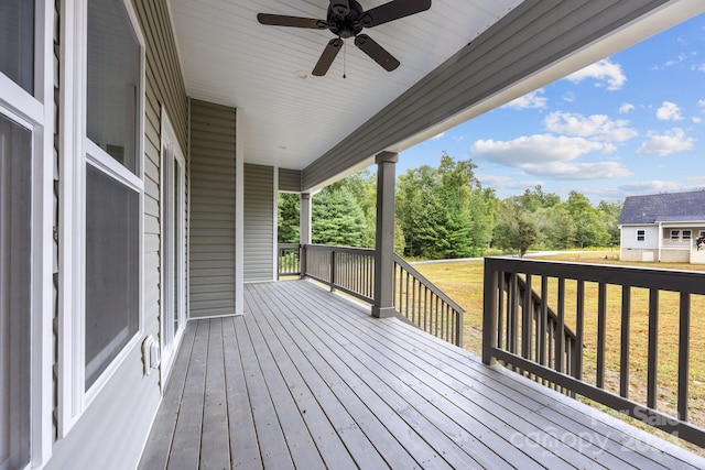 deck featuring ceiling fan and a lawn