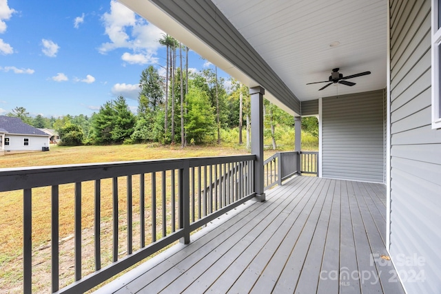 deck featuring ceiling fan and a yard