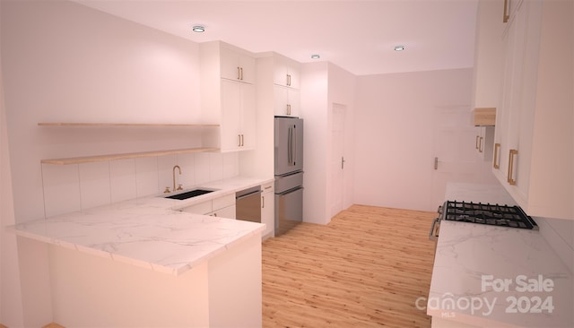 kitchen featuring white cabinetry, light hardwood / wood-style flooring, stainless steel appliances, sink, and decorative backsplash