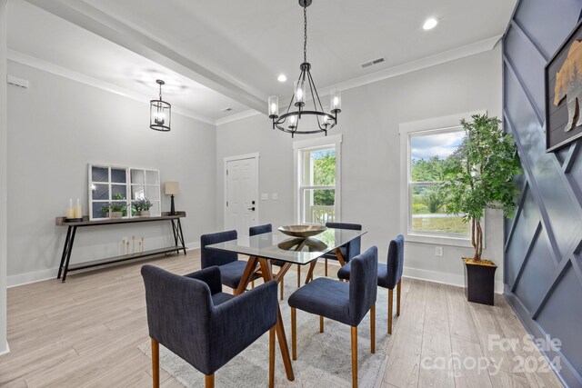 dining area with a healthy amount of sunlight, light hardwood / wood-style floors, and ornamental molding