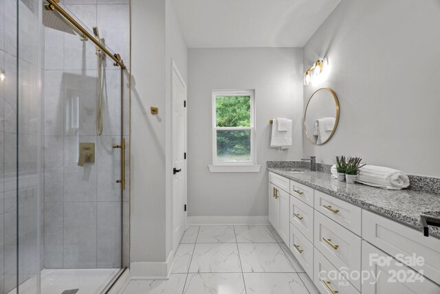 bathroom featuring a shower with door and vanity