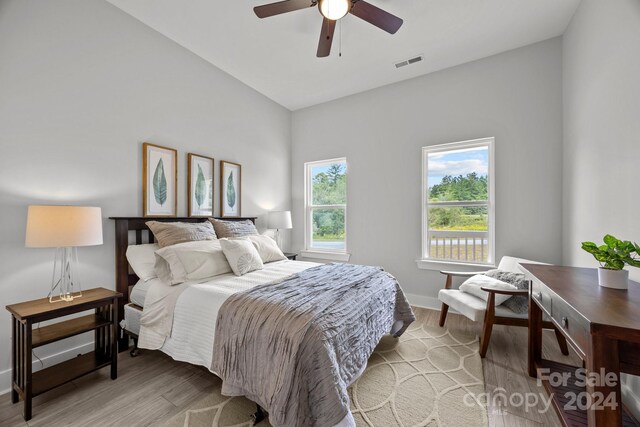 bedroom featuring light wood-type flooring, vaulted ceiling, and ceiling fan