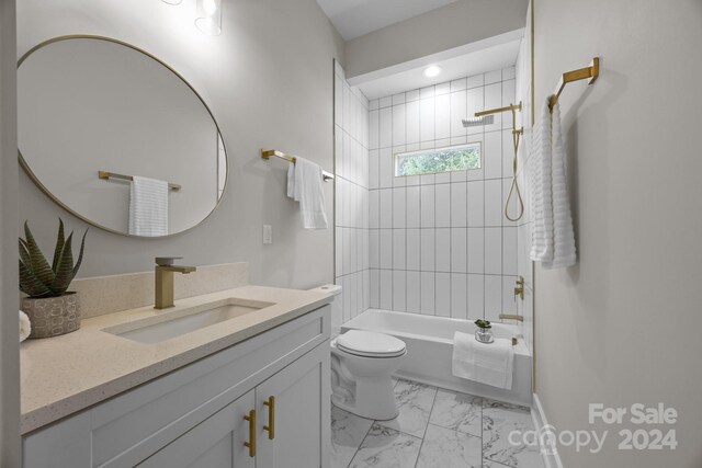 full bathroom featuring tiled shower / bath combo, vanity, and toilet