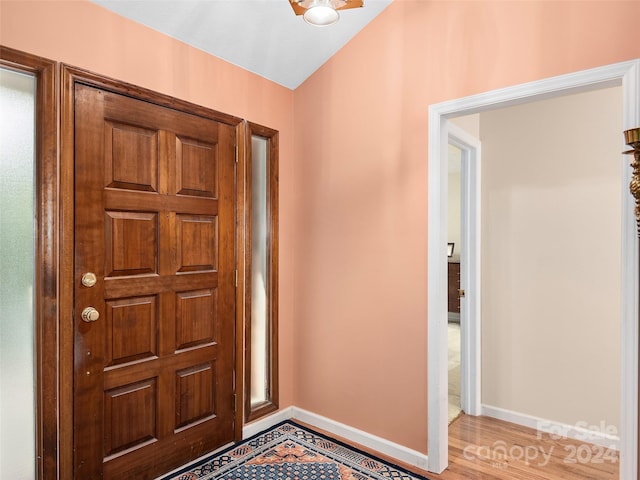 foyer entrance with light hardwood / wood-style floors and lofted ceiling