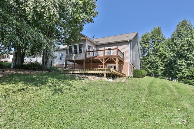 back of house featuring a lawn and a wooden deck