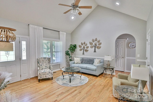 living room featuring hardwood / wood-style flooring, ceiling fan, and high vaulted ceiling