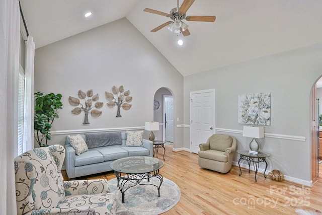 living room featuring hardwood / wood-style flooring, ceiling fan, and high vaulted ceiling