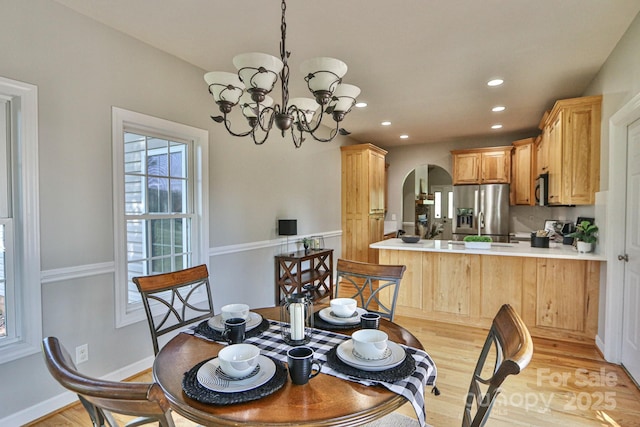 dining area with a notable chandelier and light hardwood / wood-style floors