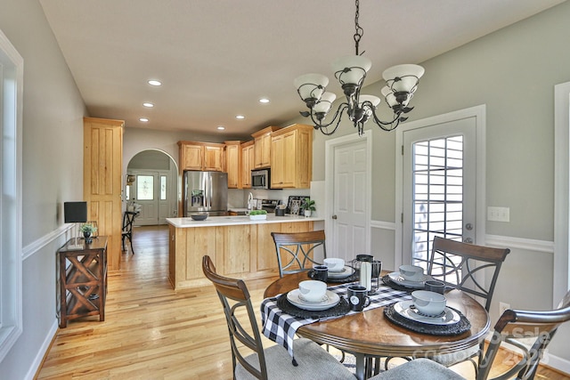 dining area featuring light hardwood / wood-style floors and an inviting chandelier