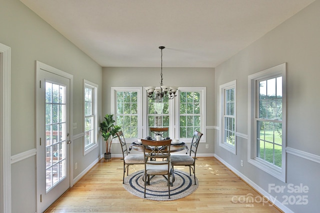 dining area featuring light hardwood / wood-style floors and an inviting chandelier