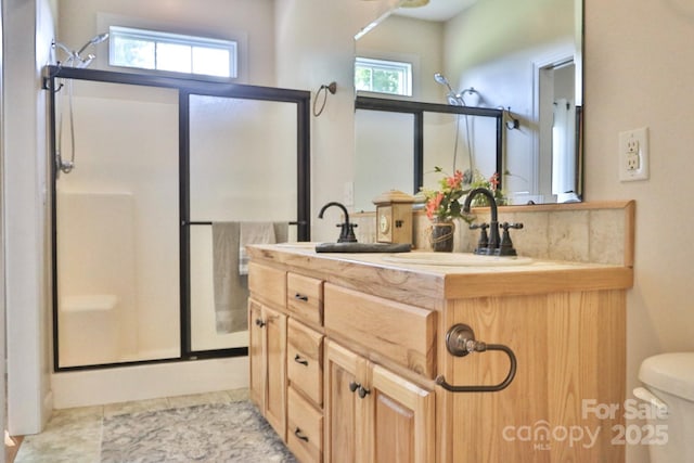 bathroom featuring vanity, toilet, and a shower with door