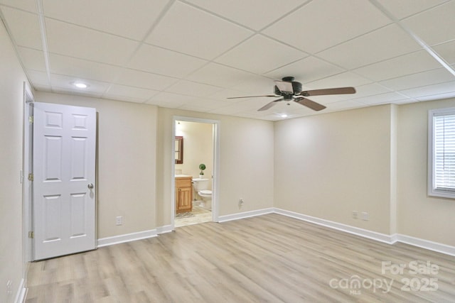 spare room featuring a drop ceiling, ceiling fan, and light hardwood / wood-style flooring