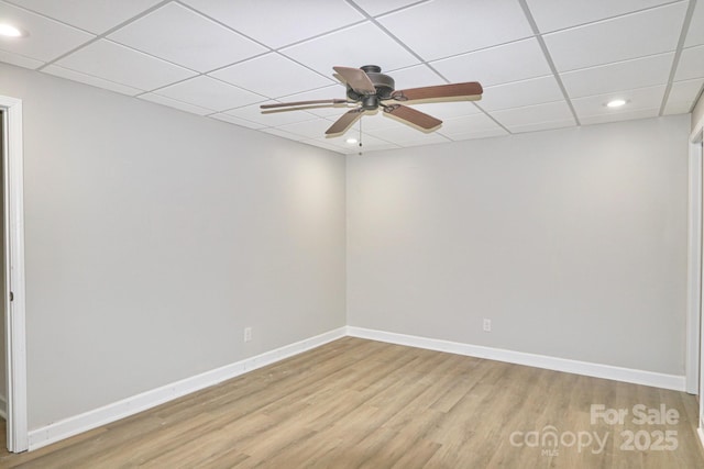 unfurnished room with light hardwood / wood-style flooring, a drop ceiling, and ceiling fan