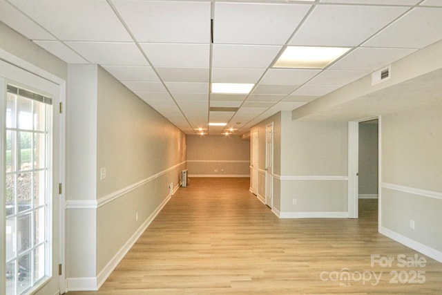 hallway featuring a paneled ceiling and light wood-type flooring