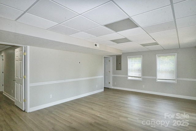 empty room with wood-type flooring and a drop ceiling