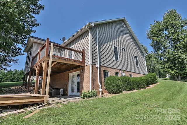 view of side of property featuring french doors, a yard, central AC unit, and a wooden deck