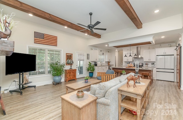 living room featuring light hardwood / wood-style flooring, sink, beam ceiling, and ceiling fan