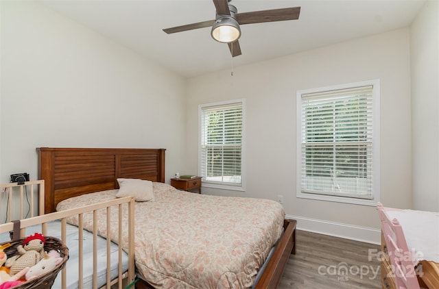 bedroom featuring multiple windows, ceiling fan, and dark wood-type flooring