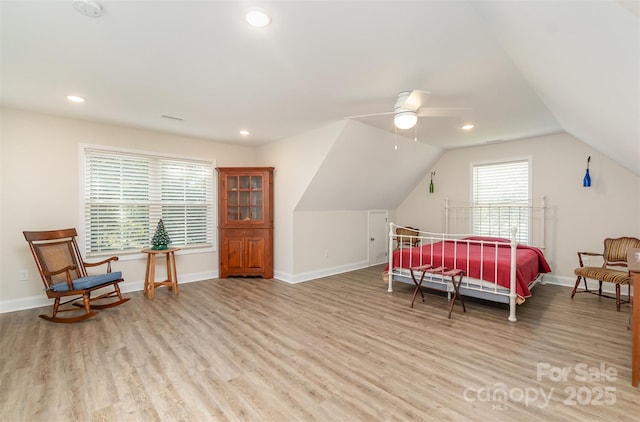 bedroom with light wood-style flooring, baseboards, and vaulted ceiling