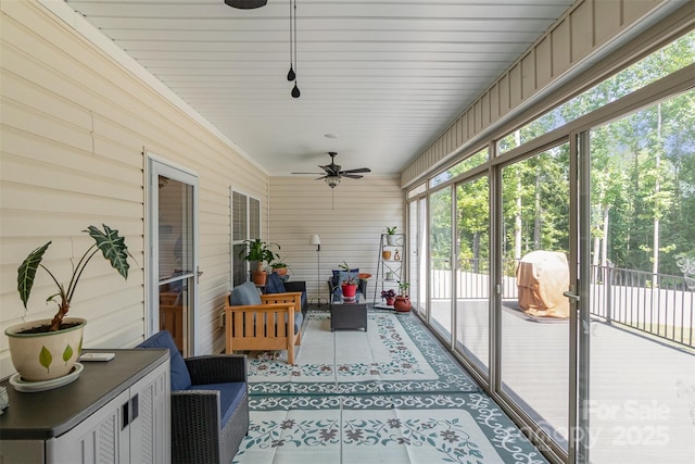 sunroom / solarium featuring ceiling fan