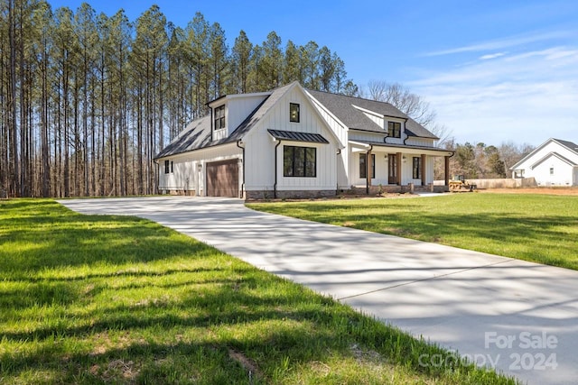 modern farmhouse style home with a front lawn and a garage