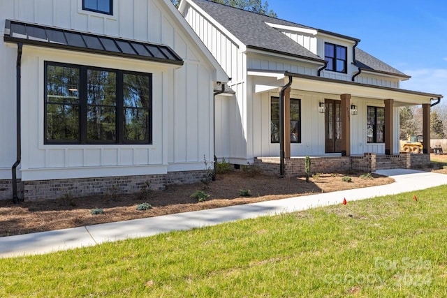 view of front of home with covered porch and a front lawn