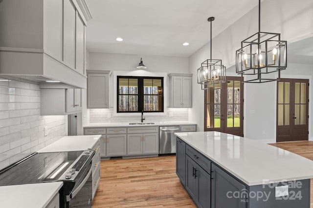 kitchen featuring backsplash, sink, appliances with stainless steel finishes, light hardwood / wood-style floors, and gray cabinets