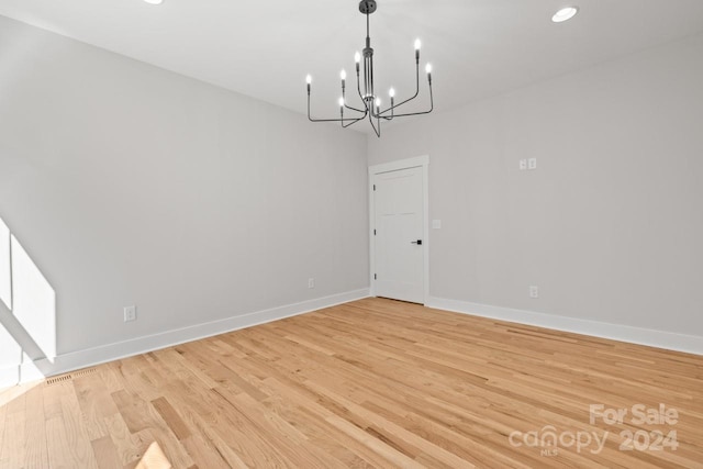 unfurnished dining area featuring light hardwood / wood-style flooring and a chandelier