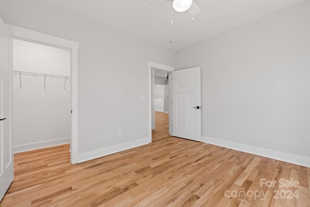 unfurnished bedroom with ceiling fan, light hardwood / wood-style flooring, and a closet