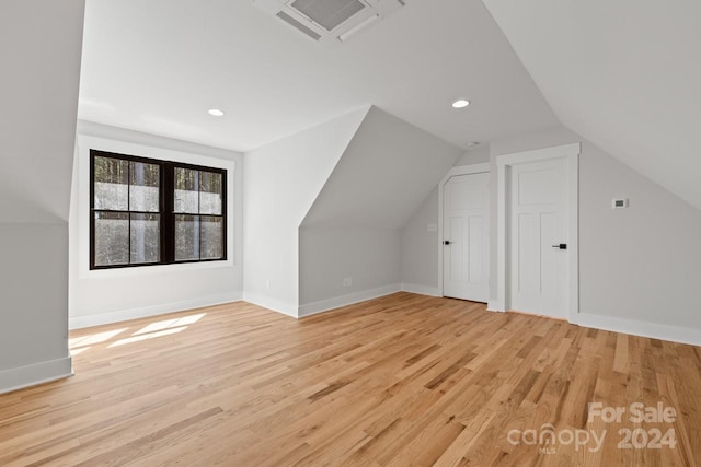 bonus room with vaulted ceiling and light hardwood / wood-style flooring