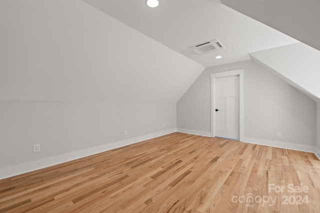 additional living space featuring light hardwood / wood-style flooring and lofted ceiling