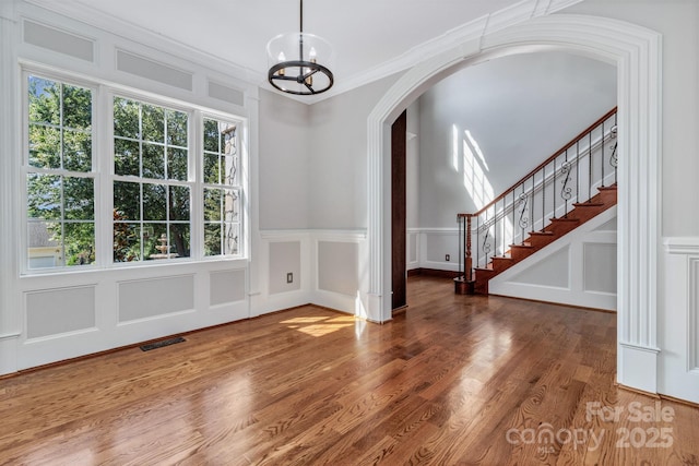 interior space with ornamental molding, hardwood / wood-style floors, and a chandelier