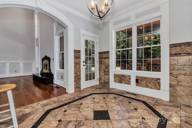 interior space with ornamental molding and an inviting chandelier