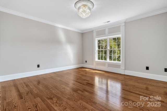 unfurnished room featuring crown molding, a chandelier, and hardwood / wood-style flooring