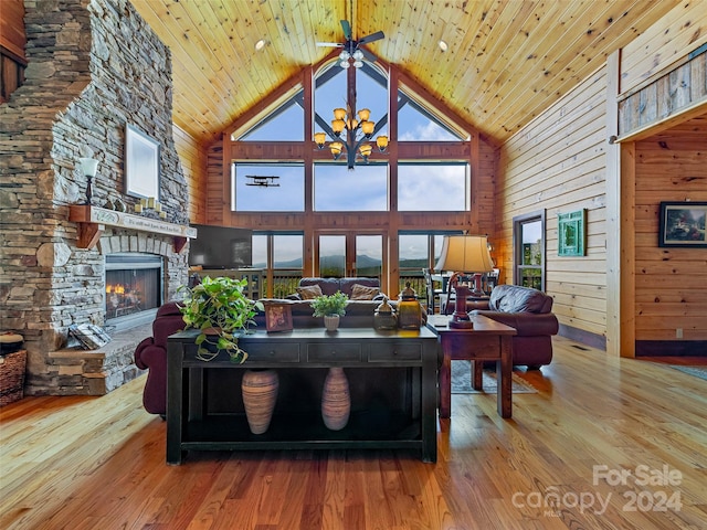 living room featuring wood walls, wooden ceiling, a fireplace, high vaulted ceiling, and hardwood / wood-style flooring