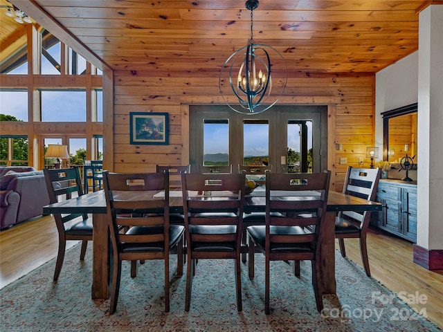 dining area with hardwood / wood-style flooring, wooden walls, wood ceiling, a chandelier, and vaulted ceiling with beams