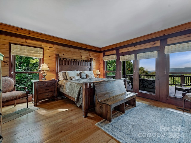 bedroom with light wood-type flooring, multiple windows, and access to exterior